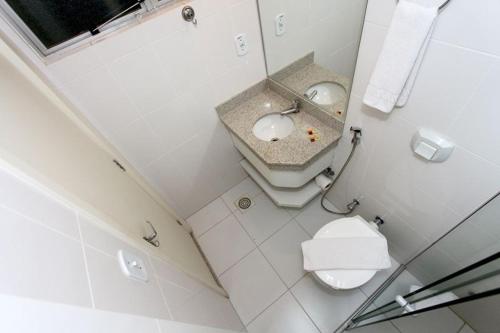 a white bathroom with a sink and a toilet at Império Romano - Splash e Acqua Park in Caldas Novas