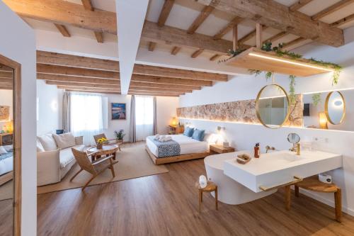 a bathroom and a living room with a sink and a couch at Hotel S'Antiga Adults Only in Es Mercadal