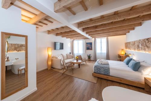 a bedroom with a king sized bed and a bathroom at Hotel S'Antiga Adults Only in Es Mercadal