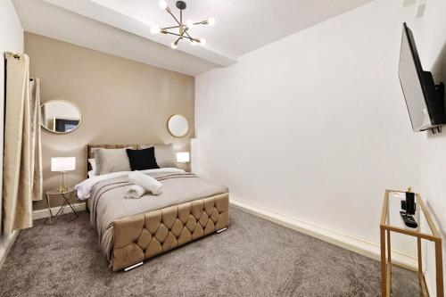 a bedroom with a bed and a flat screen tv at Stylish 2BR Luxury Retreat with 65" Smart TV in Kent