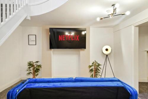 a blue couch in a room with a television at Stylish 2BR Luxury Retreat with 65" Smart TV in Kent