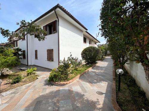 a white house with a walkway in front of it at Villetta Saba in Olbia