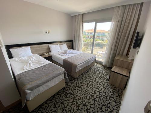 アイワルクにあるElisa Hotelのベッド2台と窓が備わるホテルルームです。