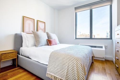 a bedroom with a bed and a large window at Hells Kitchen 1BR w Doorman nr Central Park NYC-525 in New York