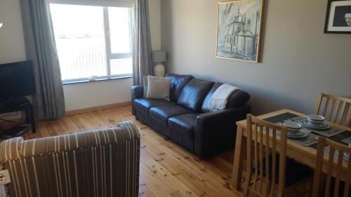 sala de estar con sofá y mesa en Broadhaven Bay Apartment en Belmullet