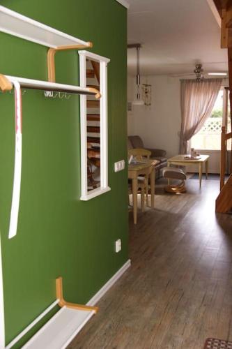 a room with a green wall and a living room at Charmantes lütt Eckhus Zingst in Zingst