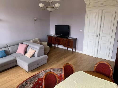 a living room with a couch and a tv at 3 Bedroom Lux Apartment Center in Wrocław