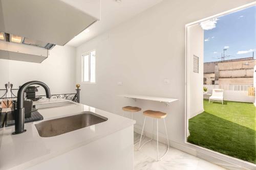 a kitchen with a sink and a large window at Indulge en Sevilla Cuna in Seville