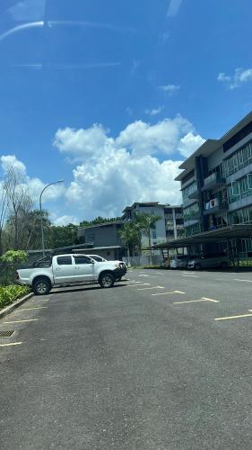 uma limusina branca estacionada num parque de estacionamento em SDC Suite Home em Lahad Datu