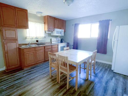 a kitchen with a table and chairs and a refrigerator at Omeo Suites Glass Beach in Fort Bragg