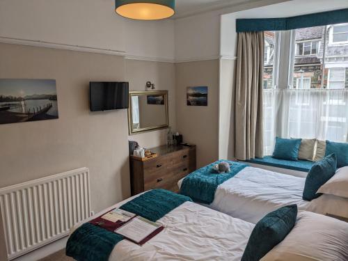 a bedroom with two beds and a window at Avondale Guest House in Keswick