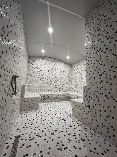 a bathroom with a tub and a tiled wall at Elifim Resort Hotel 