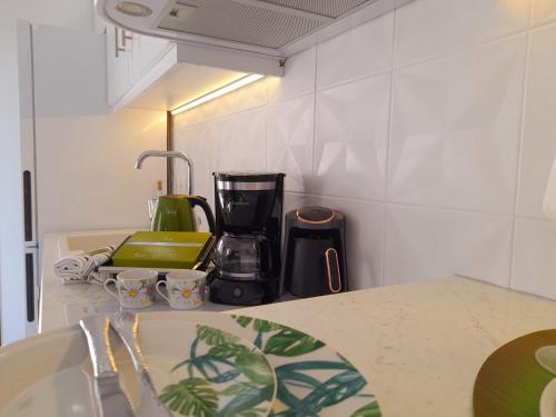 a kitchen counter with a coffee maker and cups on it at AGORA LUXURY LOFT in Ayios Nikolaos Sithonia