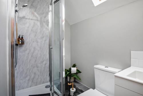 a bathroom with a shower and a toilet and a sink at Stylish and Spacious 3 Bed Apartment with Parking by Ark SA in Sheffield