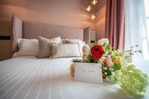 a bed with a card and flowers on it at Hotel Duomo Firenze in Florence
