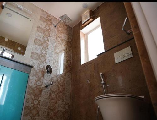 a bathroom with a bath tub and a window at The Periwinkle Homestay Bhimtal in Bhīm Tāl