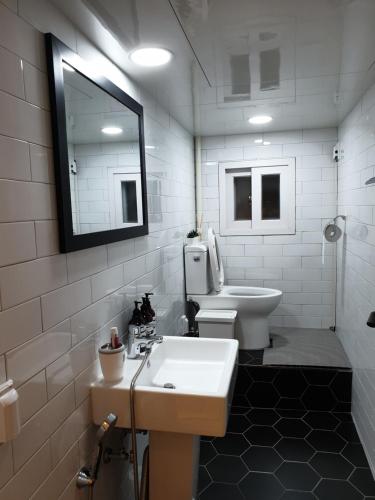 łazienka z umywalką, toaletą i lustrem w obiekcie Complace D w Seulu