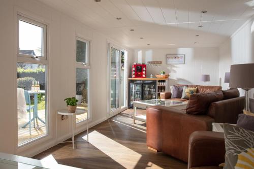 ein Wohnzimmer mit einem Sofa und einem Tisch in der Unterkunft Gyllyngvase House in Falmouth