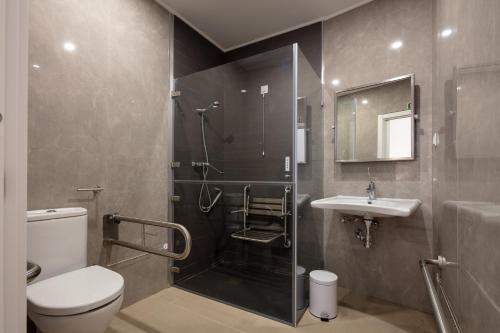 a bathroom with a shower and a toilet and a sink at The ICONS Lisbon Central Hotel in Lisbon