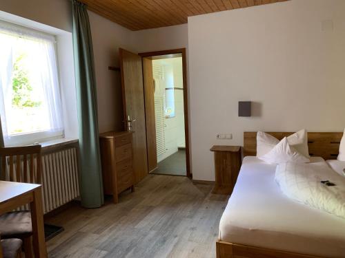 a bedroom with a bed and a door to a bathroom at Alpenhotel Sonneck - mit Bergbahnticket in Bad Hindelang