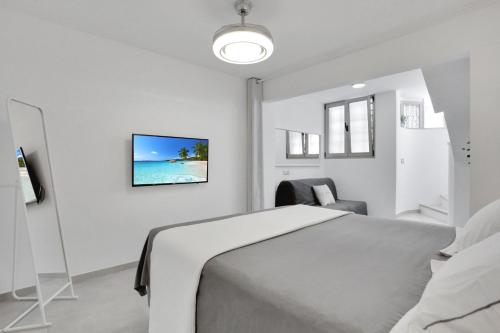a bedroom with a bed and a tv on the wall at 7even in Corralejo