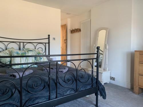 a bedroom with a black bed and a dresser at Primrose Cottage - Tideswell, Peak District in Tideswell