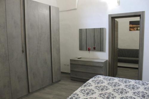 Schlafzimmer mit einem Bett, einer Kommode und einem Spiegel in der Unterkunft Da Nonna Concettina by Salento com in Aradeo