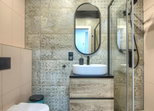 a bathroom with a sink and a mirror at Studio Bueno 5.2 - ACCO RENT in Gdańsk
