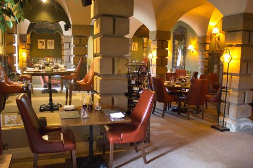 un restaurant avec des tables et des chaises dans un bâtiment dans l'établissement Lumley Castle Hotel, à Chester-le-Street