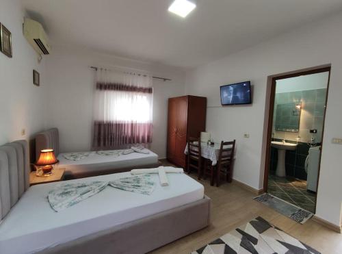 um quarto com 2 camas, uma mesa e uma secretária em Dona's Studio Apartment em Gjirokastër