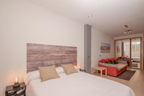 マドリードにあるModern and Lovely in Chuecaのベッドルーム(白いベッド1台、赤いソファ付)