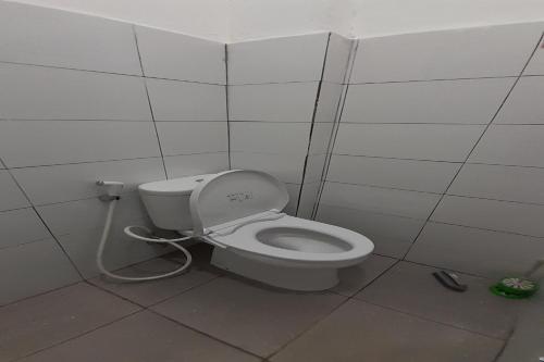 a bathroom with a white toilet in a stall at SPOT ON 92481 Modena Homestay Syariah in Medan