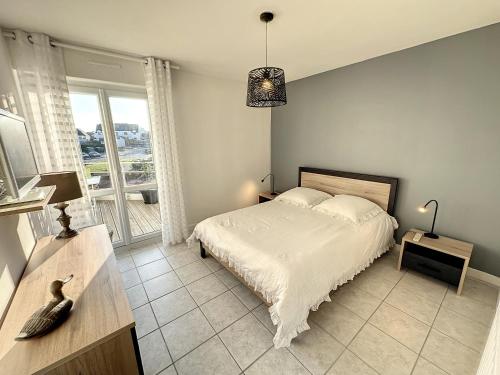 um quarto com uma cama e uma grande janela em LOVELY ! T2 Hyper Cocooning – Terrasse em Larmor-Plage