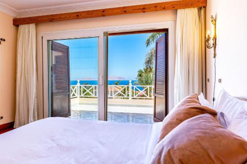 Sharm and Charme at Sheraton Resort في شرم الشيخ: غرفة نوم مع سرير وإطلالة على المحيط