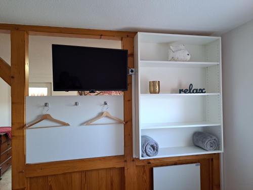 a living room with white shelves and a flat screen tv at Ferienwohnung am Kalkweg in Bad Sooden-Allendorf