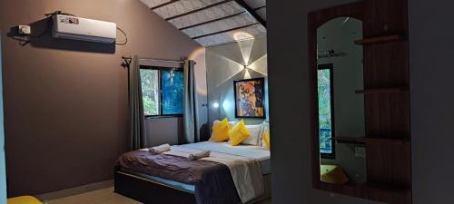 1 dormitorio con cama y espejo grande en Shankar Homestay en Hampi