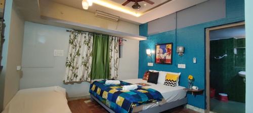 a small bedroom with a bed and a bathroom at Shankar Homestay in Hampi