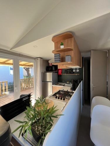 Il comprend une cuisine équipée d'une cuisinière. dans l'établissement Mobil-home à 100m des plages - tout équipé - 8 pers - Camping Siblu 4 étoiles, à Canet