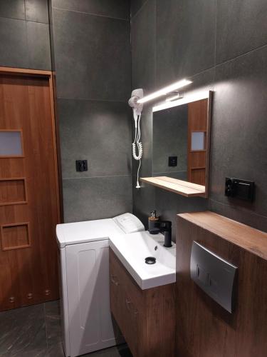 a bathroom with a white sink and a mirror at Apartament Przy Rynku in Lewin Kłodzki