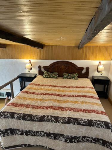 Casa Rural El Pasil في أرونا: غرفة نوم بسرير كبير مع مواقف ليلتين