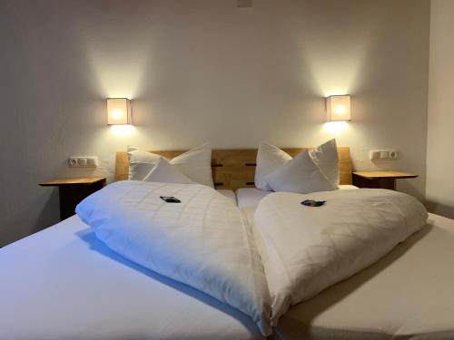 two beds in a room with white sheets and pillows at Alpenhotel Sonneck - mit Bergbahnticket in Bad Hindelang