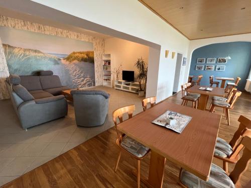 ein Wohnzimmer mit einem Sofa und einem Tisch in der Unterkunft Gästehaus Niederhof in Sundhagen-Niederhof