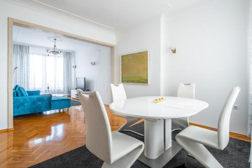 a white dining room with a white table and chairs at Vitosha Str 2BD White & Blue Apt in Sofia
