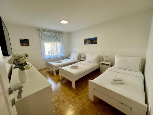 uma sala de estar com duas camas e um sofá em Clara Ljubljana Apartment em Liubliana