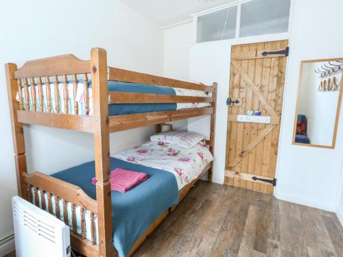ein Schlafzimmer mit einem Etagenbett mit einer Leiter in der Unterkunft Eweleaze in Dorchester