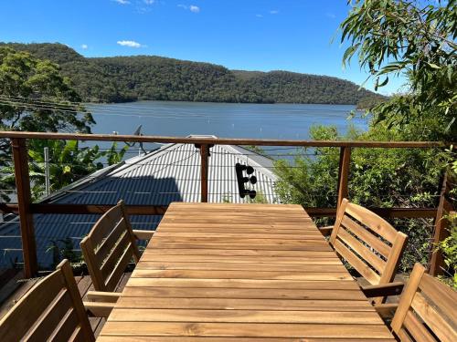 a wooden deck with a view of a lake at Cosy Cottage Above the Hawkesbury w/ Jetty in Mooney Mooney