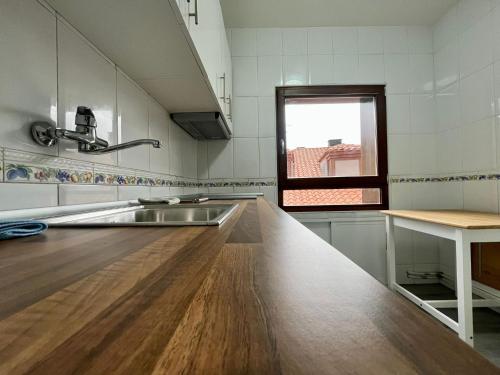 eine Küche mit einer Spüle und einer hölzernen Arbeitsplatte in der Unterkunft Centro Historico Valentin Palencia Vut 09/440 in Burgos