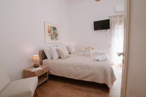 a white bedroom with a bed and a television at Luxury apartment, in Heraklion in Heraklio