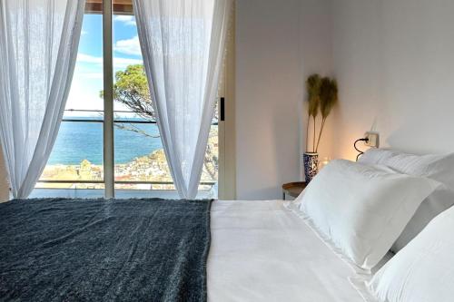 a bedroom with a bed with a view of the ocean at Pool and sea views apartment with 1 parking space in Tossa de Mar