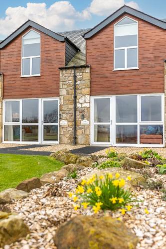 a house with white windows and a yard at Woodside Apartments in St. Andrews